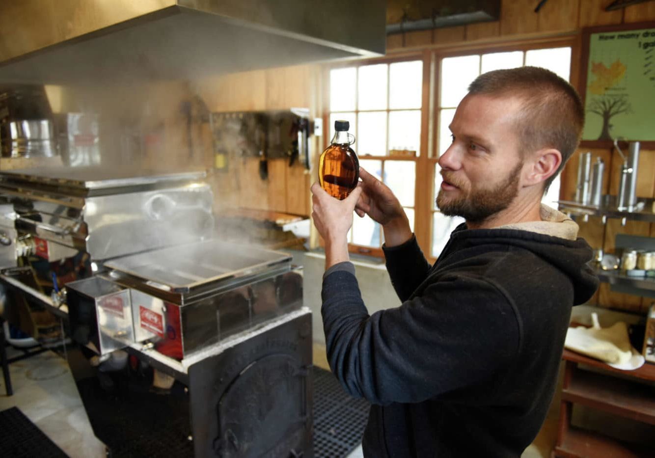 Farm manager Mark Mogensen shows a bottle of Grade B maple syrup while demonstrating the maple sugaring process on the evaporator during First County Bank Maple Sugar Fest Sundays at Stamford Museum & Nature Center in Stamford, Conn. Sunday, Feb. 26, 2023. The event featured maple sugaring demonstrations and tree tapping, syrup tasting, children's activities, local vendors, and more. The event continues on March 5 and 12 starting at 10 a.m.
